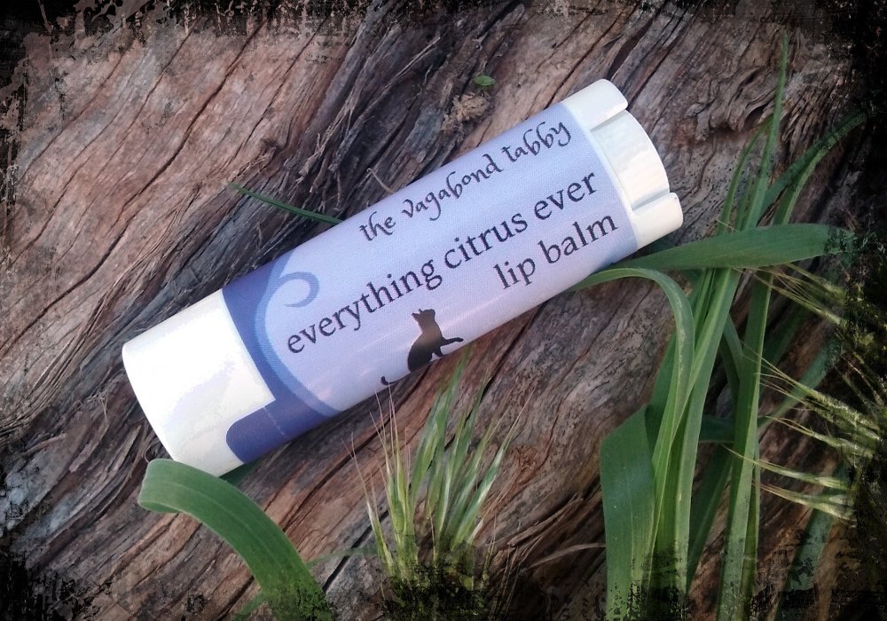 A white lip balm tube; the label says 'everything citrus ever'.