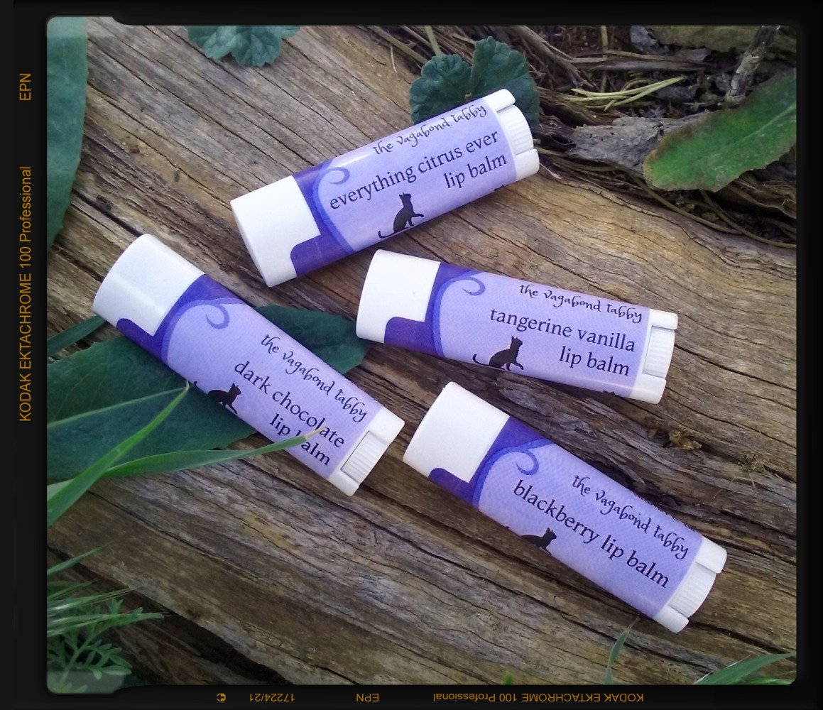 Four white lip balm tubes; the labels each name a different flavor.