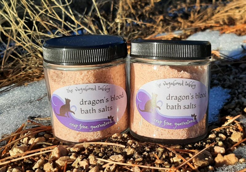 Two clear glass jars filled with reddish-brown bath salts.