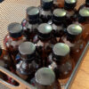 Several amber glass bottles sit in a small metal box, just big enough to hold three bottles across.