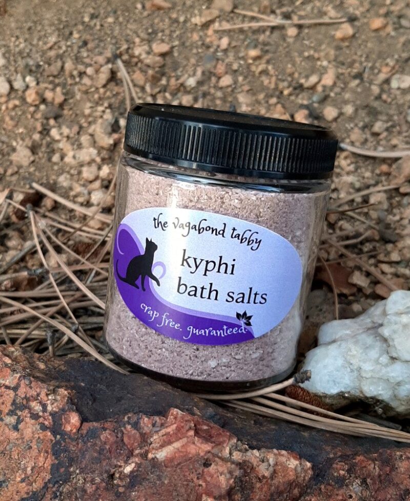A clear glass jar filled with brown bath salts.