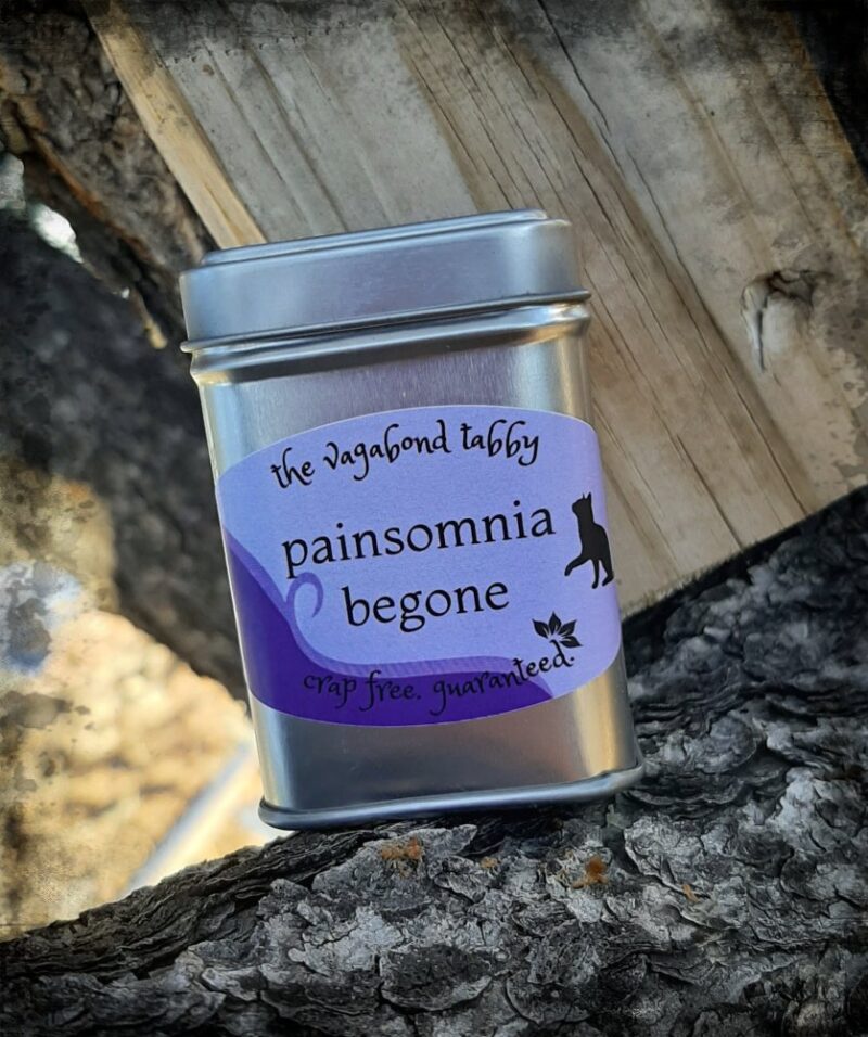 A stainless steel tea tin; the label says "painsomnia begone".
