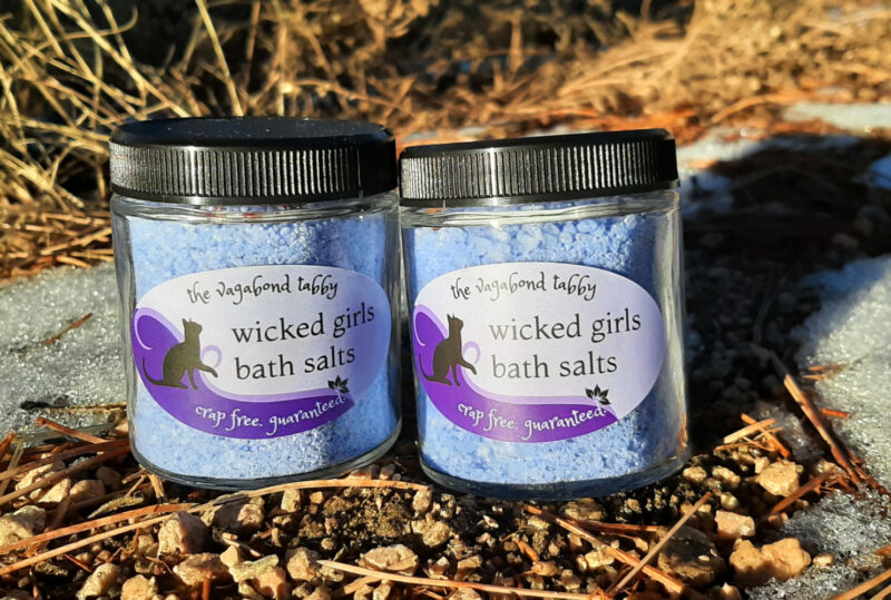 Two clear glass jars filled with blue bath salts, labeled "wicked girls saving ourselves".
