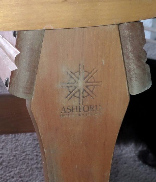 Closeup of part of the spinning wheel, which says Ashford.