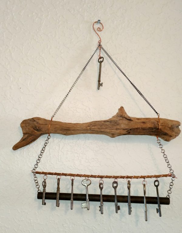 Instead of a chain, the keys are now hanging from a thin wooden dowel, which runs between the two chains that hold up the tube chime. The whole thing is hung from a hook on the wall.