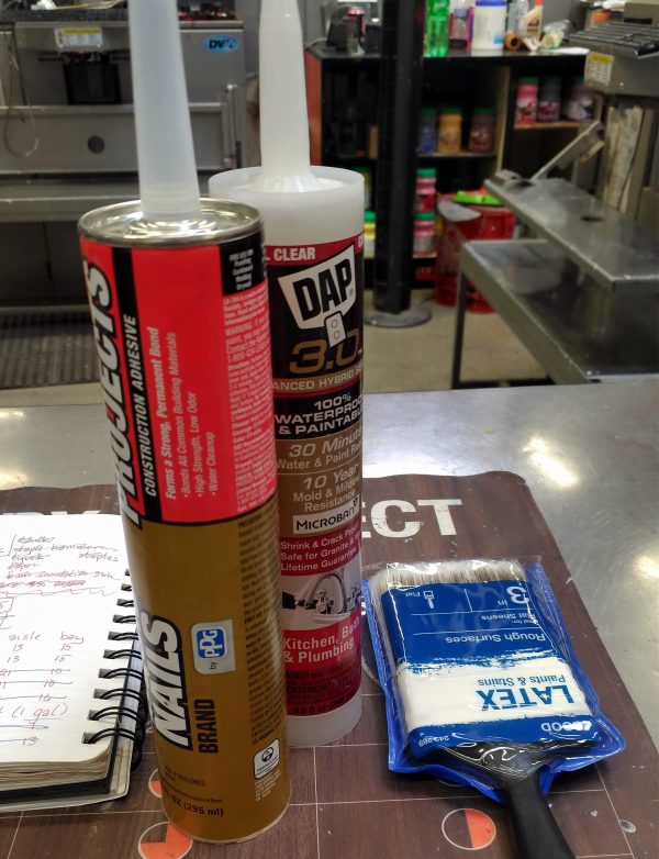 Still life on the paint counter: the notebook, a medium-cheap paintbrush, & two different kinds of caulk. That's C A U L K in case you were concerned.