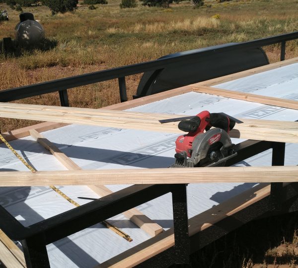 A bunch of 2x2 boards laying across the trailer railings. Also a circular saw.