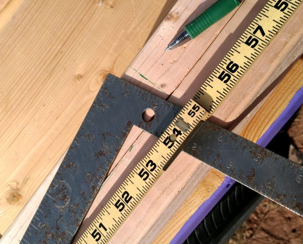 Closeup of a pair of 2x2s, various measuring instruments, & a green pen.