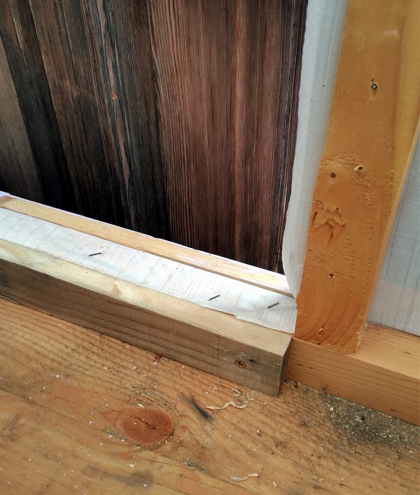 The bottom part of the door hole, which now has a piece of wood fastened along the bottom.