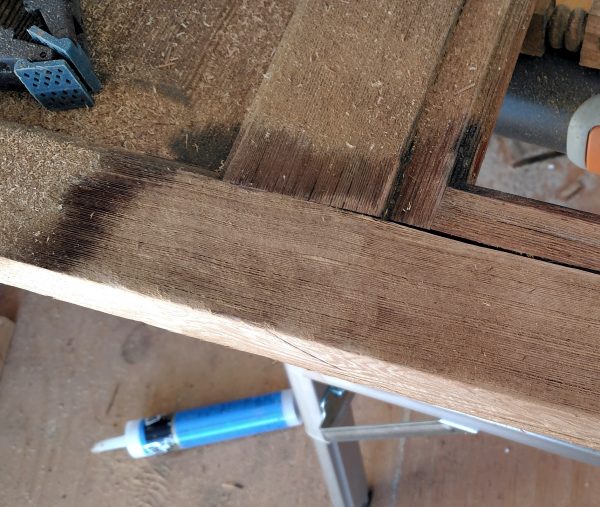 A section of the door, part of which has been sanded until it is ... less rough than the rest. Which is not to say that it has achieved actual smoothness.