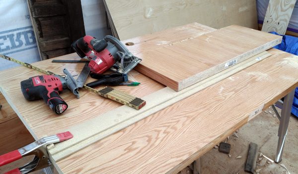 One end of the cutting guide is properly clamped down. The other end, which doesn't reach to the far side of the door, is held down by a really heavy-looking hunk of wood. Don't do this, it doesn't work.