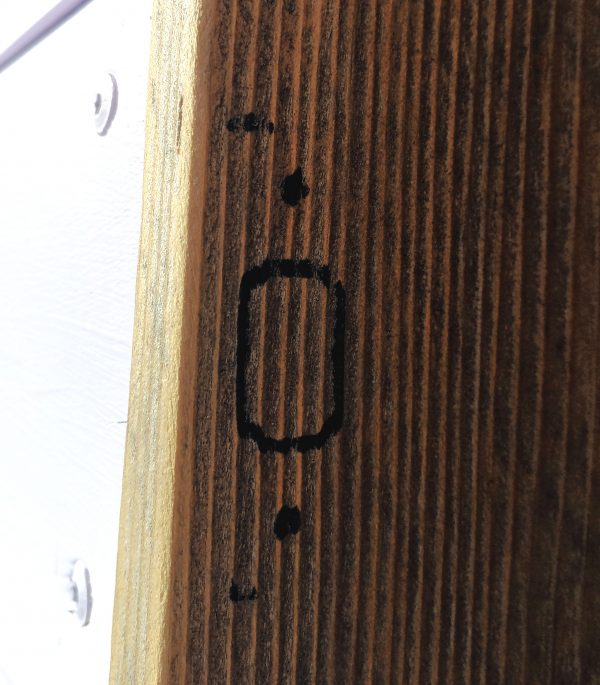 A bit of doorframe, upon which is drawn, in Sharpie, the rough outline of the strike plate. That's the metal bit around the hole where the latch goes.