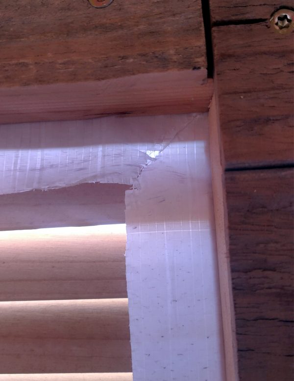 A corner of the window; the housewrap is cut diagonally out from the corner, so it can fold flat along the inside edge of the window.