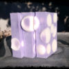 Three bars of soap, purple embedded with white spheres.