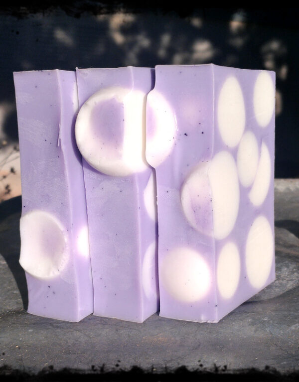 Three bars of soap, purple embedded with white spheres.