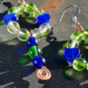 Simple hoops of beads, lime green glass with blue hearts in between; each earring also dangles a strand of round beads, blue green blue, ending in a copper spiral.