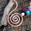 One of the hammered spirals. THinner copper wire wraps partway around the spiral, then loops once around the driftwood.