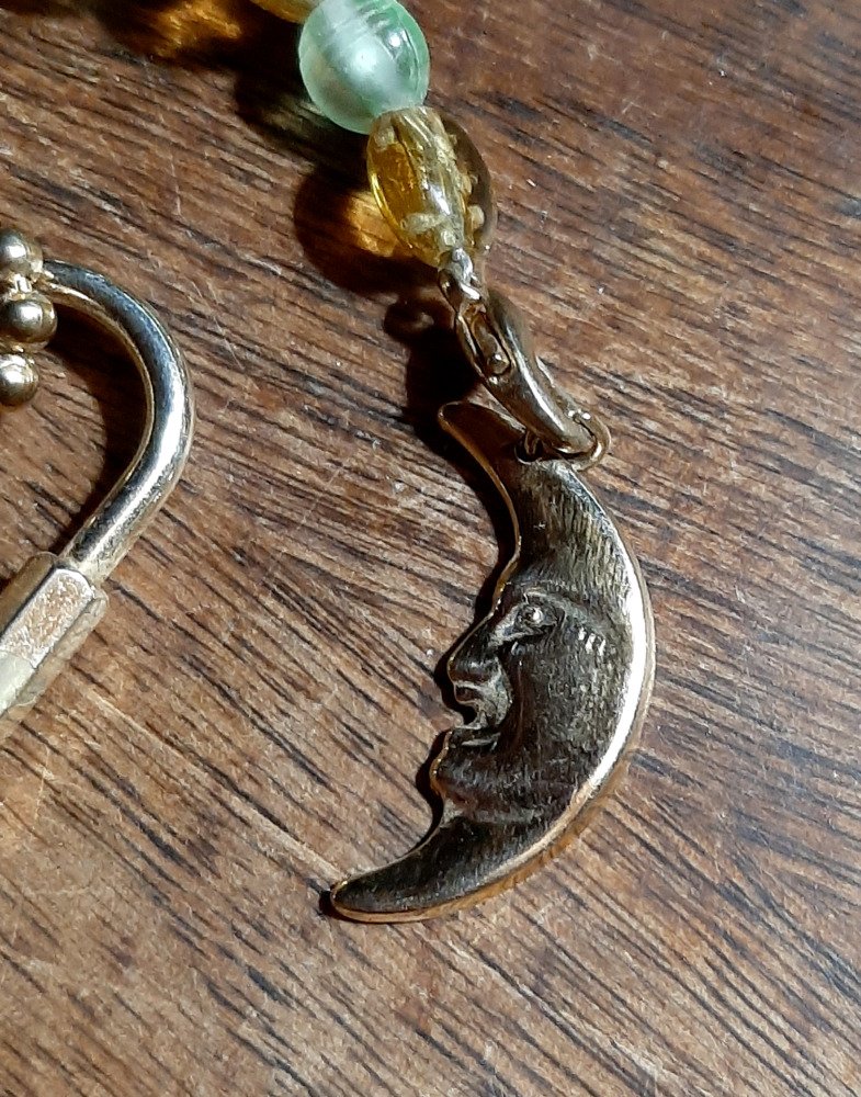 A closer view of the crescent moon. The metal is pale gold in color.