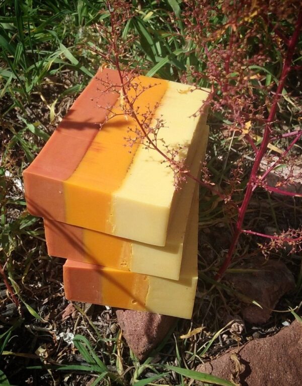 Three bars of soap, each colored in three layers: red, orange, and yellow.
