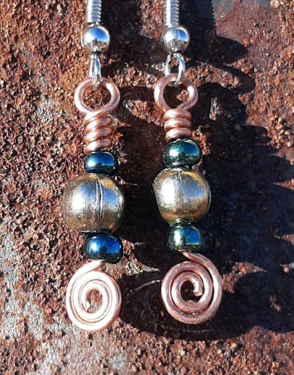Each earring has a round brass bead with a deep green bead to either side, all strung on copper wire that ends at the bottom in a neat spiral.