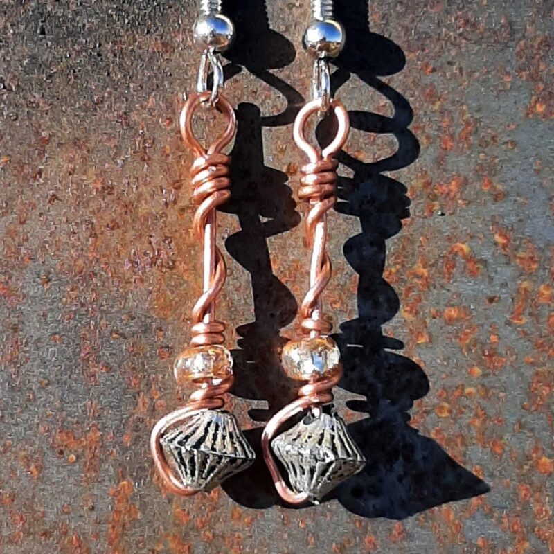 Each earring has a bicone silver-colored bead with a clear yellow glass bead above, all strung on copper wire that curves back up around each bead, then twists around itself.
