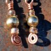 Each earring has a round brass bead with a sparkly orange-brown bead to either side, all strung on copper wire that ends at the bottom in a neat spiral.