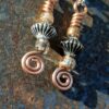 Each earring has a biconic silver-colored bead between two sparkly brown-orange beads, all strung on copper wire that ends at the bottom in a neat spiral.