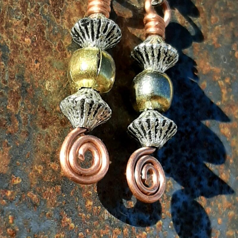 Each earring has a round brass bead between two biconic silver-colored beads, all strung on copper wire that ends at the bottom in a neat spiral.