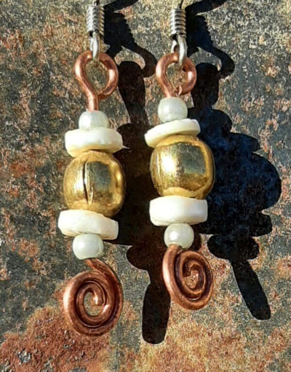 Each earring has a round brass bead with a disc-shaped bone bead above and below, and a small round pale blue bead to either side of those. All are strung on copper wire that ends at the bottom in a neat spiral.