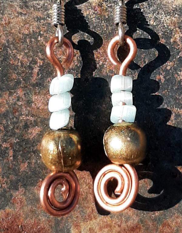 Each earring has a round brass bead with three pale blue beads above it. All are strung on copper wire that ends at the bottom in a neat spiral.