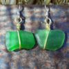 Each earring is a very roughly rectangular piece of green creek glass, simply wrapped in a single loop from top to bottom with gold-colored wire.