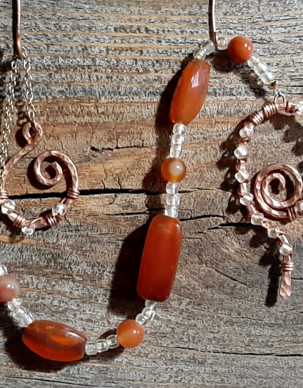 Lovely deep orangey-brown beads set off by lil glass beads that are MOSTLY clear but have just a tint of yellow, plus a pointer & finger loop of hammered copper wire.